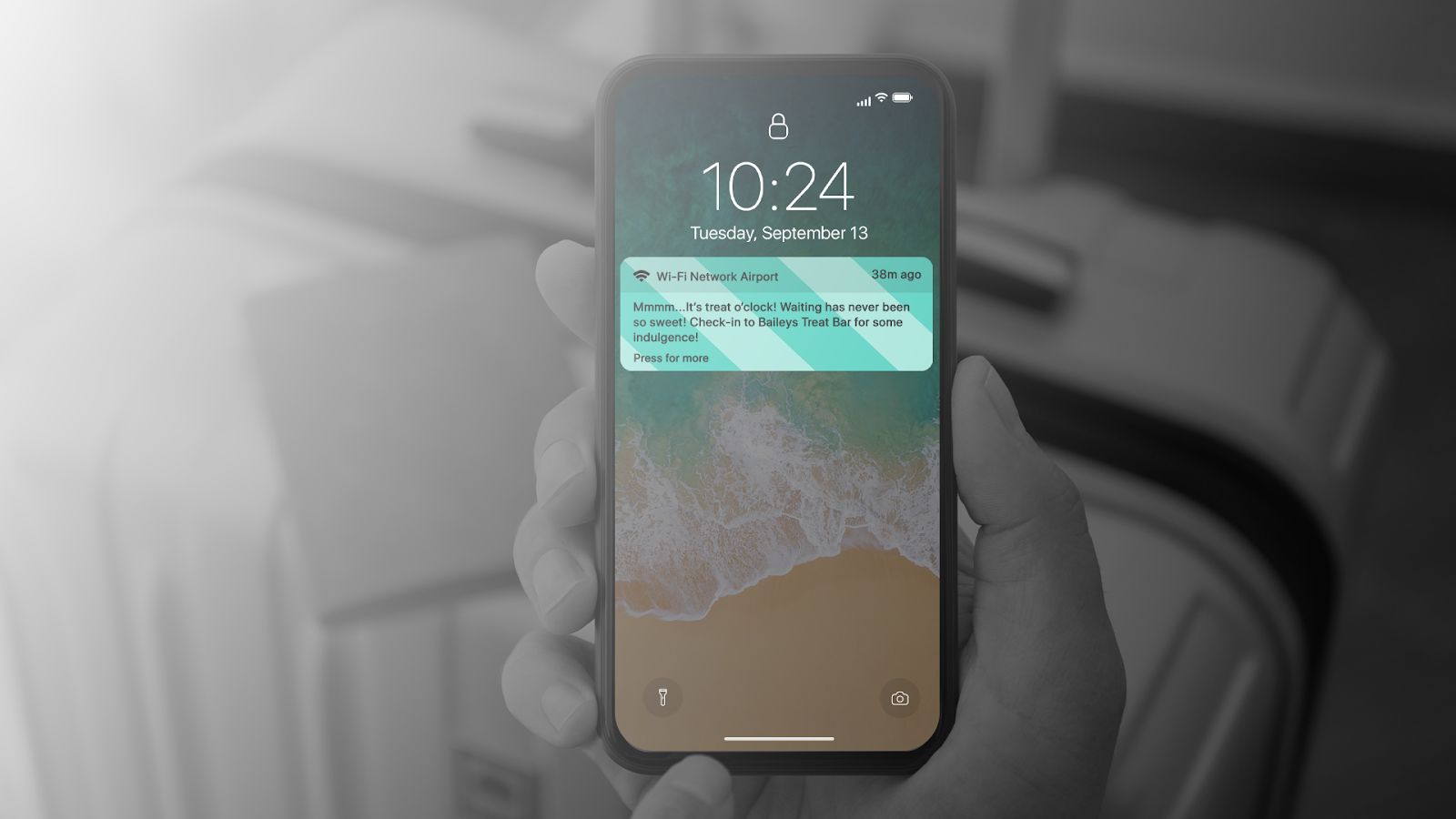 A phone lock screen showing a geo-targeted Baileys Treat Bar notification at an airport